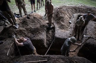 Украинские военные роют окоп. 