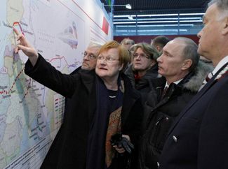 Russia’s then-Prime Minister Vladimir Putin and Finland’s then-President Tarja Halonen look at a map upon arriving at the railway station in St. Petersburg via the Allegro train. December 12, 2010.