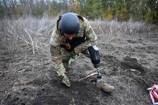 Сапер Национальной полиции Украины Андрей Ильков, в прошлом году потерявший ногу в результате взрыва мины, проводит операцию по разминированию поля в Изюмском районе Харьковской области. В состав отряда входят двое саперов, которые вернулись к работе после потери конечностей во время разминирования под Херсоном и Харьковом