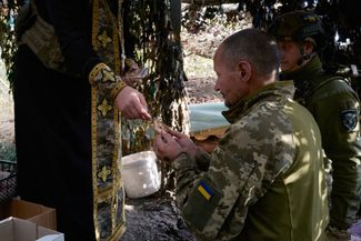 Военный капеллан дарит икону пехотинцу