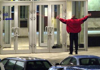 An unknown man tries to enter the seized Dubrovka Theater on the night of October 24. Federal Security Service (FSB) agents cordoned off the building on the evening of October 23. According to the FSB, terrorists spent several months preparing their assault on the theater.