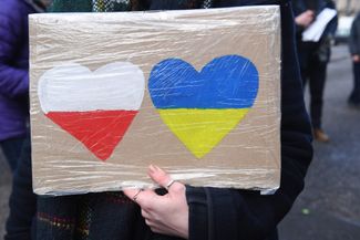 A protester holds a sign outside the Russian consulate in Edinburgh. February 25, 2022