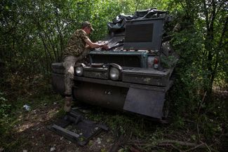 Солдат ремонтирует британский бронетранспортер FV103 Spartan