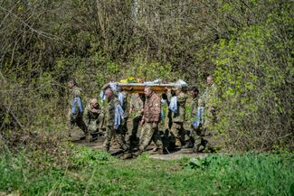 Украинские военные несут гроб с телом своего товарища Валентина Матвиенко, погибшего в боях под Бахмутом. Матвиенко хоронят в его родном селе Великий Самбор Сумской области