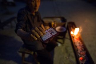 An Uyghur resident of Kashgar with an ID card. Only those who carry these special cards have the right to speak to foreigners.