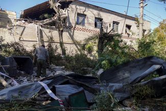 Житель Одессы среди обломков после того, как ракета попала в здание склада