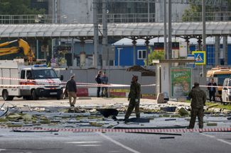 Сотрудники служб безопасности на месте падения одного из беспилотников