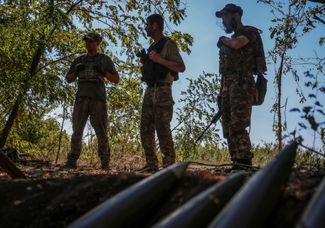 Военнослужащие ВСУ на фоне артиллерийских снарядов во время боев в Донецкой области