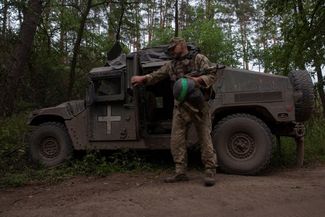 Военнослужащий рядом с американским фургоном «Хамви» (HMMWV)