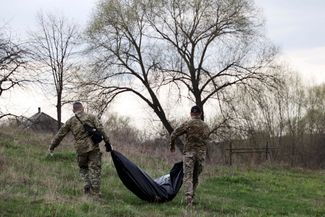 Члены группы военно-гражданского сотрудничества ВСУ переносят останки российского солдата в селе Синиха, расположенном примерно в 20 километрах от Купянска и 100 километрах от Харькова. ВСУ <a href="https://www.dw.com/ru/vojska-rf-pocti-polnostu-usli-iz-harkovskoj-oblasti/a-63083571" rel="noopener noreferrer" target="_blank">освободили</a> Синиху при контрнаступлении в начале сентября 2022 года