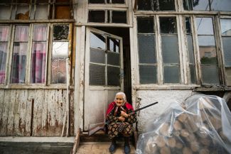 An elderly woman holds a rifle during the shelling of Nagorno-Karabakh. October 4, 2020.