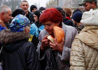 Жительница Херсона несет хлеб из пункта раздачи гуманитарной помощи