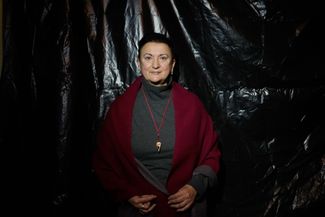 Rimma Dorosheva in her room, against the backdrop of a blacked-out window