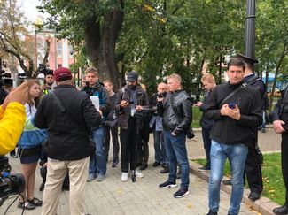 The same man carries a video camera at Moscow’s August 10 protest.