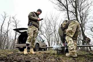 Военнослужащие взвода воздушной разведки 108-й отдельной бригады Сил территориальной обороны Украины на запорожском направлении готовятся к запуску беспилотника «Лелека-100». Слева — командир взвода