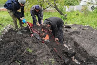 Полиция и волонтеры проводят эксгумацию тел мирных жителей, погибших в результате бомбардировок в селе Степаки недалеко от Харькова