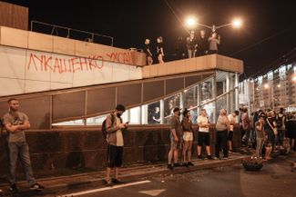 The graffiti on the building says, “Lukashenko go away!”