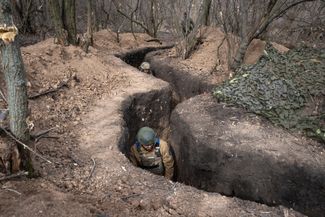 Боец 28-й отдельной механизированной бригады имени рыцарей Зимнего похода в окопе под Бахмутом