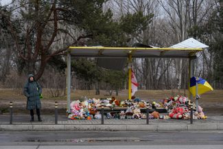 Stuffed animals and flowers left at a nearby bus stop