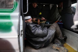 Ukrainian soldiers escort a possible Russian special forces operative.