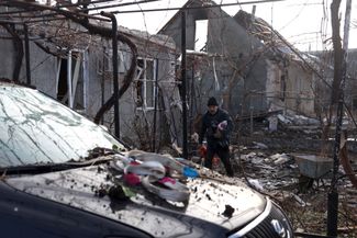 Мужчина во дворе своего дома, разрушенного в результате атаки