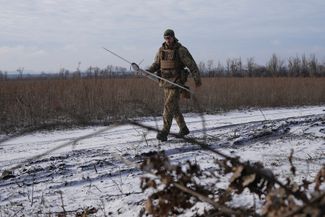 Военнослужащий подразделения воздушной разведки 45-й отдельной артиллерийской бригады ВСУ несет разведывательный беспилотник «Мара» перед его запуском недалеко от <a href="%D0%BC" rel="noopener noreferrer" target="_blank">Лимана</a> — города Донецкой области, захваченного войсками РФ в начале лета 2022-го и освобожденного ВСУ в октябре того же года. Сейчас в районе Лимана идут бои