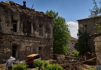 Жительница Харькова возле одного из корпусов психиатрической больницы, поврежденного российской ракетой