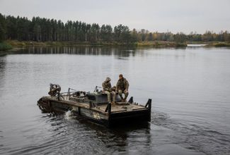 Украинские военнослужащие на лодке, на которой они отвозят гуманитарную помощь в зону отчуждения