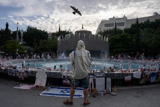 Мужчина в молитвенном платке молится возле мемориала жертвам нападения ХАМАС. Тель-Авив, 11 ноября 2023 года