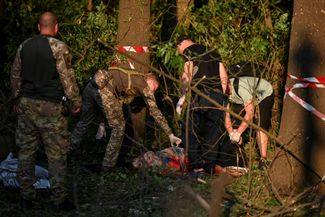 Полицейские у тела жительницы Запорожья, погибшей во время атаки 29 июля