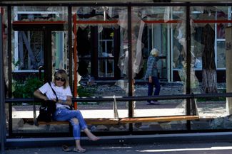 Женщина на разбитой остановке в Мариуполе. Город остается под контролем российской стороны. Как <a href="https://t.me/andriyshTime/1276" rel="noopener noreferrer" target="_blank">утверждает</a> советник мэра Мариуполя Петр Андрющенко, россияне сносят дома, под завалами которых могут находиться тела погибших