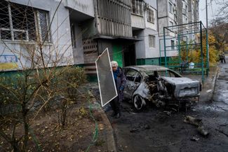 Житель Херсона убирает завалы после российской атаки по городу