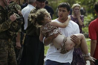 A volunteer carried a girl from the school, after the assault on the building