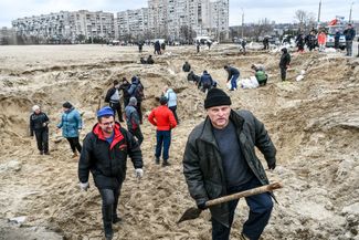 Local residents fill sandbags for fortifications at checkpoints in Kyiv.