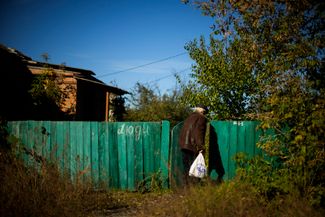 Житель Изюма несет домой продукты, выданные волонтерами. За шесть месяцев российской оккупации, как <a href="https://news.liga.net/politics/news/situatsiya-v-izyume-lyudi-nosyat-flagi-ukrainy-gorod-silno-razrushen-idet-zachistka-deputat" rel="noopener noreferrer" target="_blank">утверждают</a> украинские власти, в городе были разрушены до 90% жилых домов, больницы и школы, а из 50 тысяч человек, живших здесь до 24 февраля, около тысячи погибли