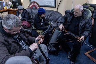 Territorial Defense volunteers inspecting weapons in Kyiv.