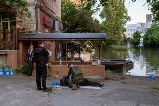 Спасатели у тела жителя Херсона, погибшего во время затопления города. Пока официальной информации о погибших в подконтрольной Украине части Херсонской области не поступало