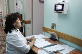 Врач смотрит на монитор, показывающий куклу в специальном контейнере, в который женщины могут анонимно оставлять нежеланных новорожденных детей, в приемном отделении городского родильного дома. Сочи, 4 ноября 2011 года