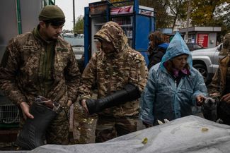 Бойцы ВСУ выбирают сапоги на рынке в Купянске