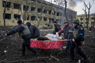 Ukrainian rescue workers carry a wounded pregnant woman out of a maternity hospitals that came under shelling in Mariupol. The woman’s child did not survive and she <a href="https://meduza.bypassnews.online/news/2022/03/14/odna-iz-beremennyh-zhenschin-postradavshaya-pri-obstrele-roddoma-v-mariupole-umerla-rebenok-tozhe-ne-vyzhil" rel="noopener noreferrer" target="_blank">died</a> on March 14.