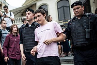 A protester whose shirt reads “intolerable” is arrested.