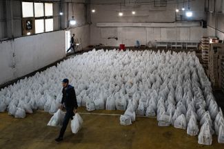 A volunteer picks up grocery bags for those in need as part of Insan’s charitable efforts for Uraza-Bairam. Makhachkala, Dagestan; May 24, 2020