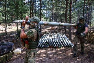 Российские военные загружают снаряды в реактивную систему залпового огня (РСЗО) «Град»