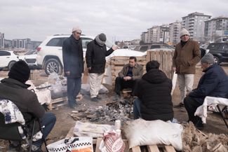 Вокруг обрушившихся многоэтажек сидят люди — ждут, плачут, ругаются: «Чего вы [спасатели] так медленно работаете? Давайте быстрее». Но когда спасатели прислушиваются к звукам из-под завалов и подают знак, наступает полная тишина.