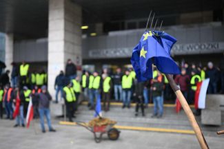 Флаг Евросоюза, насаженный на вилы. Акция польских фермеров у правительственного здания в Познани