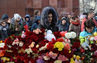 Kemerovo residents at outside burned wreckage of the “Winter Cherry” shopping center, March 26, 2018