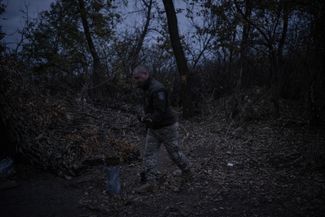 Водитель военной скорой помощи Богдан собирает дрова возле блиндажа, где помогают раненым бойцам ВСУ