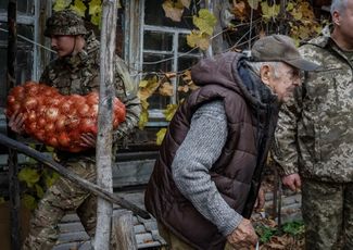 Военнослужащие ВСУ заносят доставленные ими продукты питания в дом Ивана Троянка