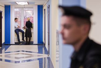 Alexey Navalny and his wife, Yulia, on October 16, 2013, in the Kirov regional court, awaiting the judges’ verdict. The court changed prison sentences against Navalny and Petr Ofitserov in the so-called “Kirovles” case from prison time to probation. The two men were nevertheless convicted of embezzling property for buying products from the “Kirovles” firm and later reselling the goods at a premium. The Russian Supreme Court’s Presidium would later send the case for a retrial, following a ruling by the European Court of Human Rights that found the two defendants’ actions to be ordinary business activity. The court in Kirov only reconvicted them, however.