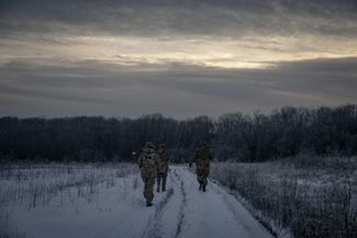 Украинские солдаты идут к своей боевой позиции рядом с Купянском Харьковской области, где сейчас идет <a href="https://meduza.bypassnews.online/feature/2022/02/26/karta-voyny-v-ukraine-posmotrite-gde-idut-boi-segodnya" rel="noopener noreferrer" target="_blank">российское наступление</a>